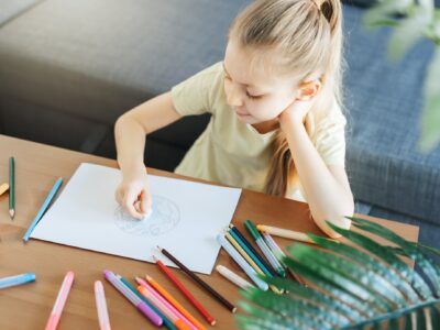 Child girl drawing with colorful pencils