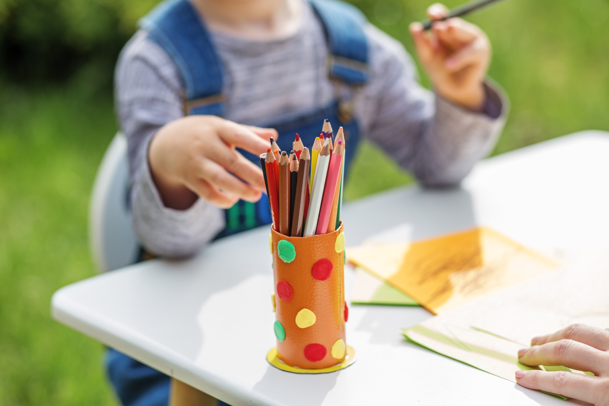 Child Selecting Colored Pencils for Drawing