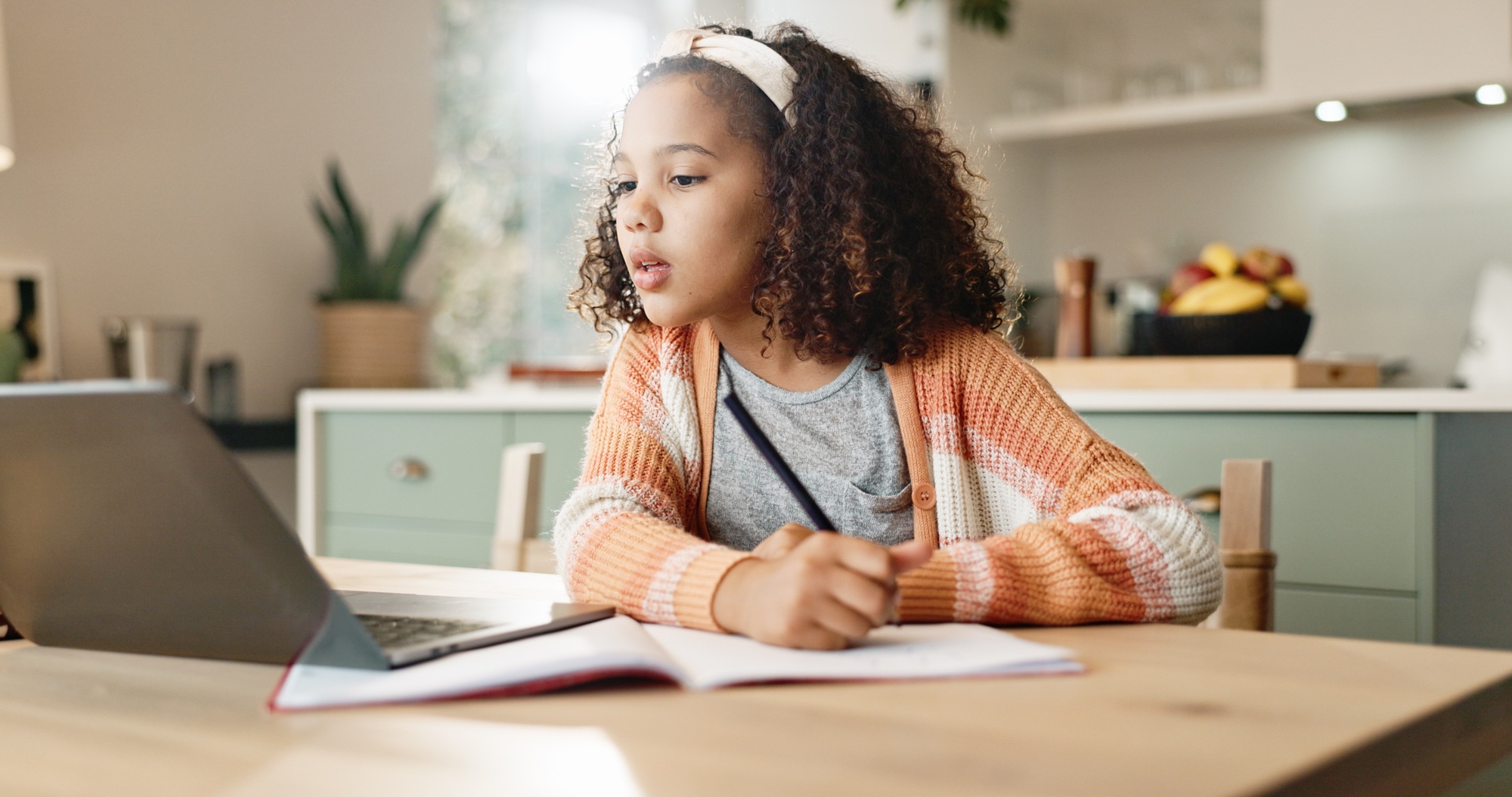 Girl child, home and writing with laptop for online learning or education, digital application and