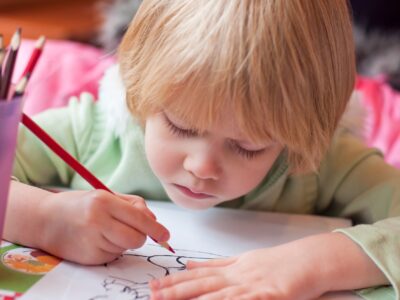 Little girl drawing coloring with color pencils. Kids art and creativity.