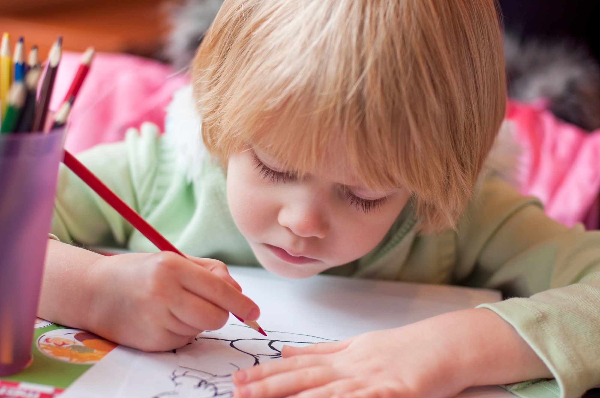 Little girl drawing coloring with color pencils. Kids art and creativity.