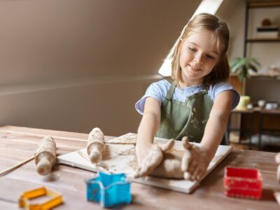 Little girl works with forms for clay at the table