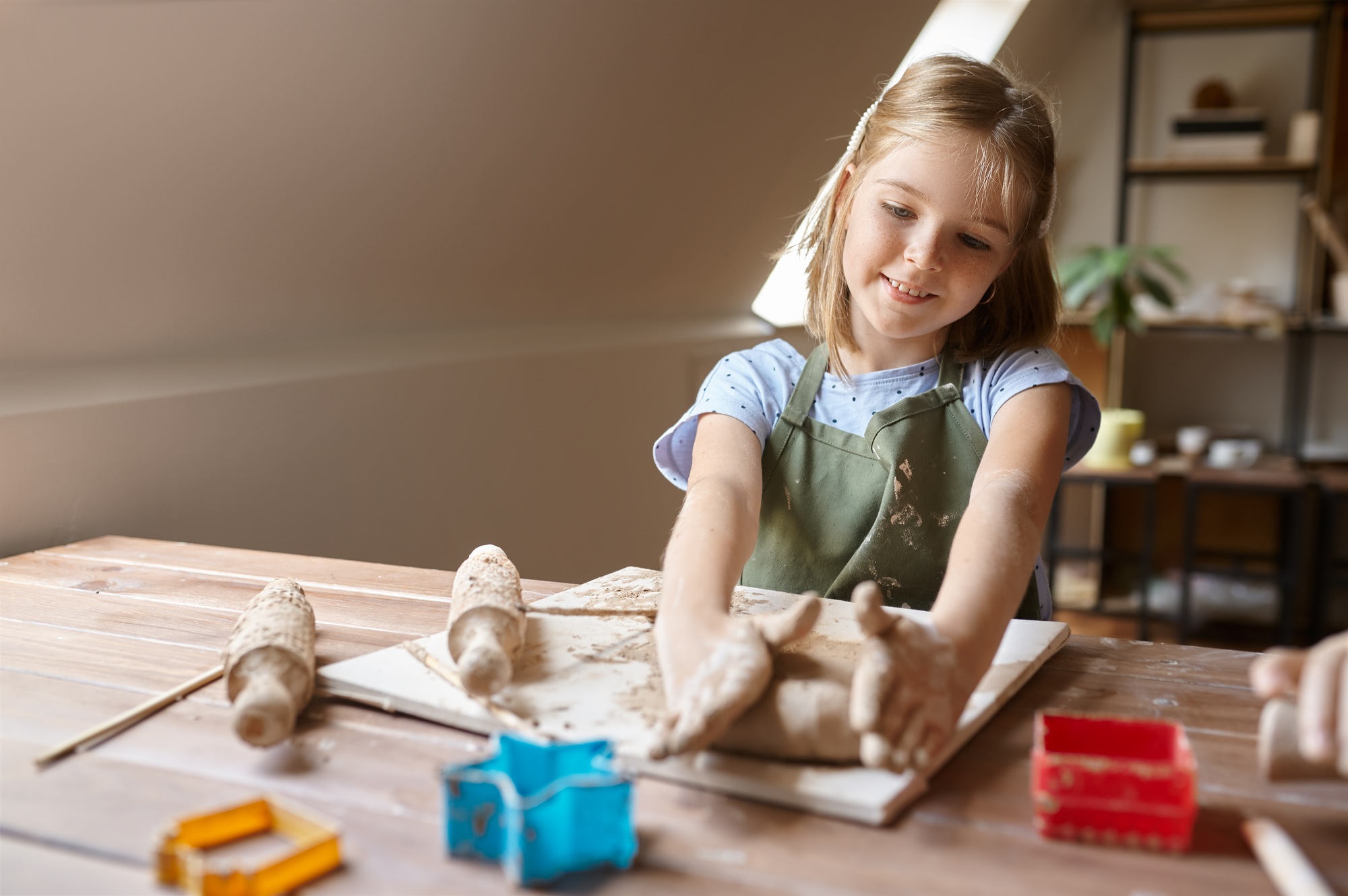 Little girl works with forms for clay at the table