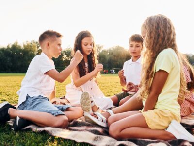Playing games. Group of happy kids is outdoors on the sportive field at daytime