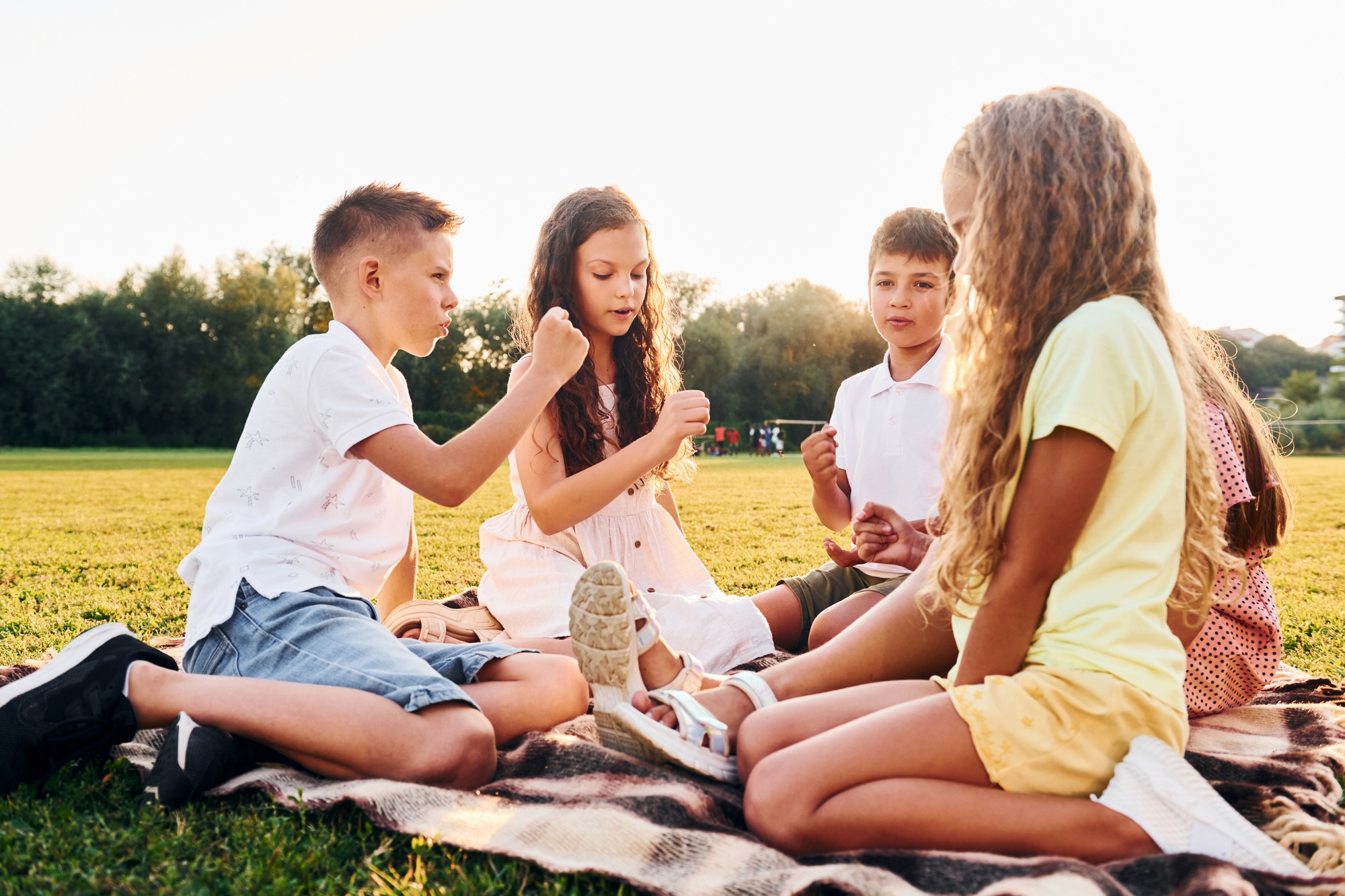 Playing games. Group of happy kids is outdoors on the sportive field at daytime